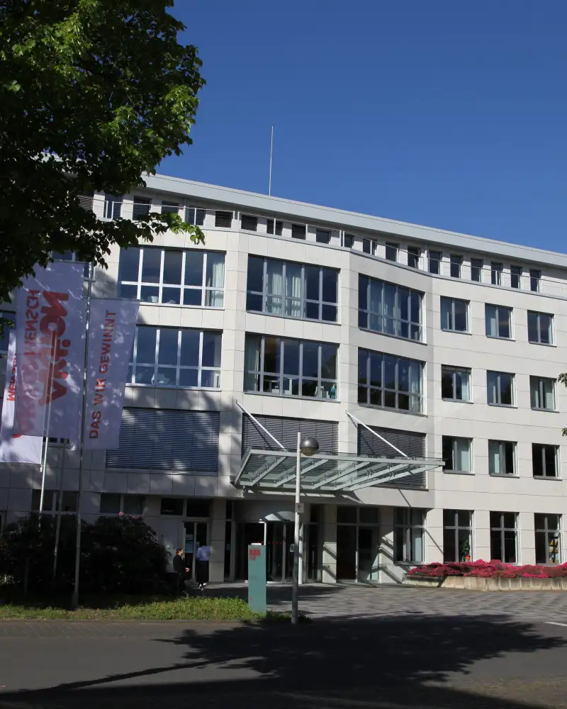 Die Geschäftsstelle der Aktion Mensch. Ein helles 4-stöckiges Gebäude mit großem Eingangsbereich.