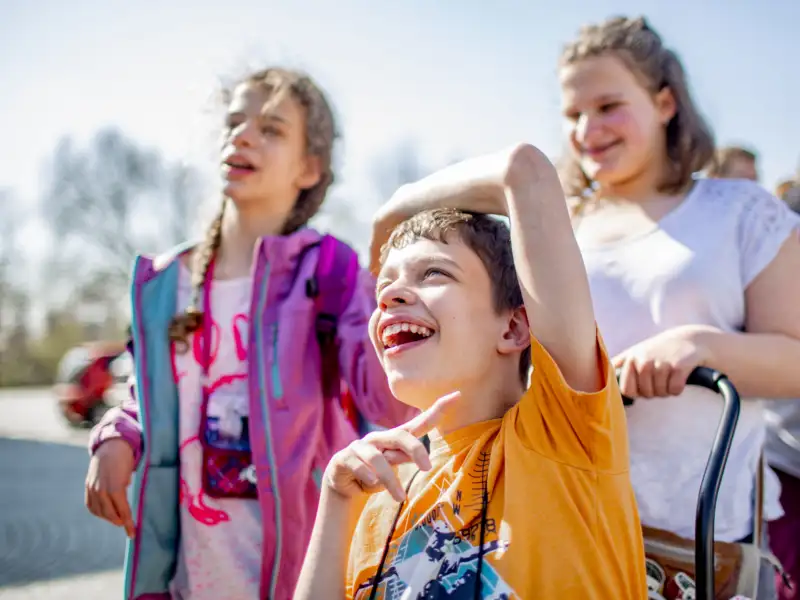 Eine inklusive Gruppe von Kindern in sommerlicher Kleidung.