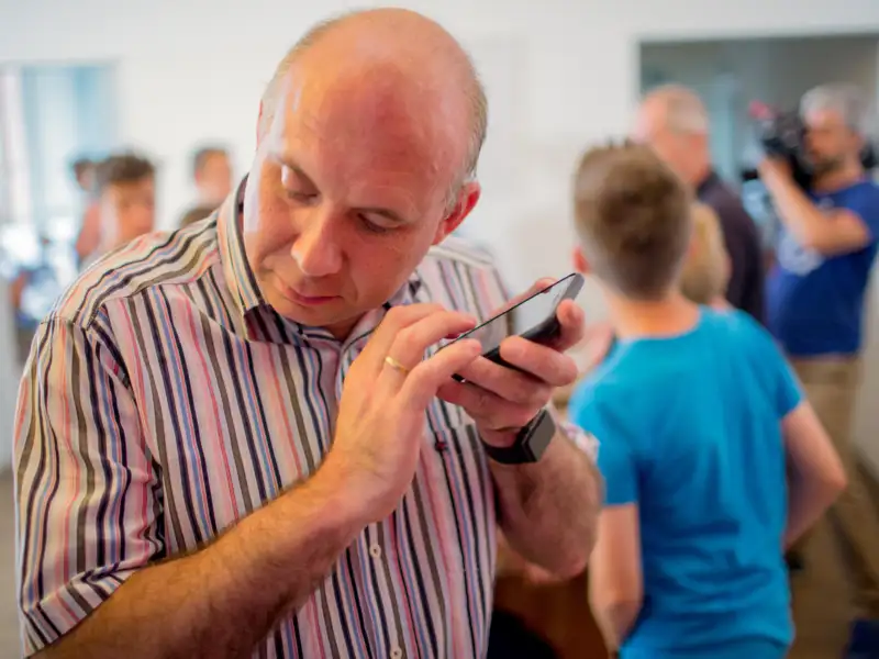 Ein Mann hält sich sein Smartphone ans Ohr.