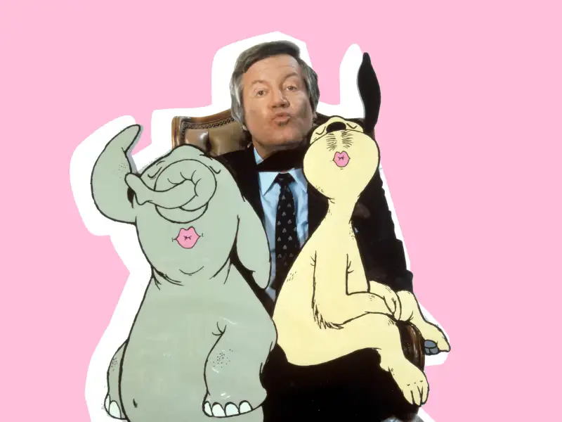 Wim Thoelke und die zwei gezeichneten Maskottechen Wum und Wendelin mit Kussmund.