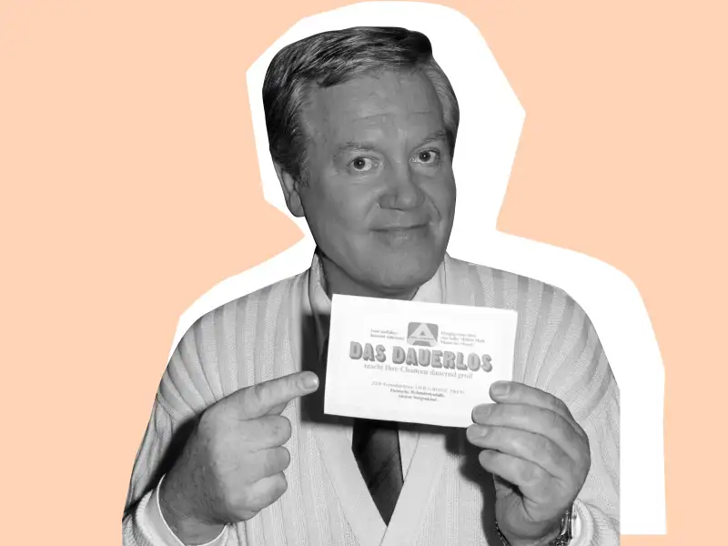 Wim Thoelke hält ein Dauerlos der Aktion Sorgenkind in der Hand.