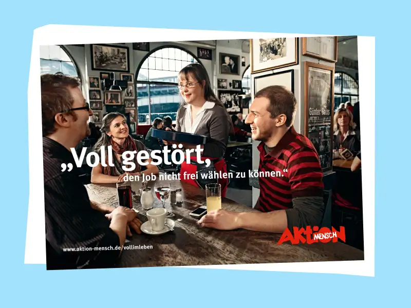 Eine junge Frau mit Down-Syndrom nimmt in einem Restaurant die Bestellung von drei Gästen auf.
