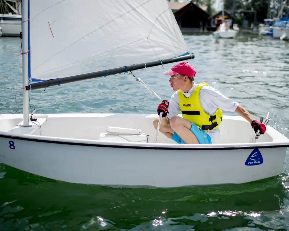 Ein junger Mann in einem kleinen Segelboot.