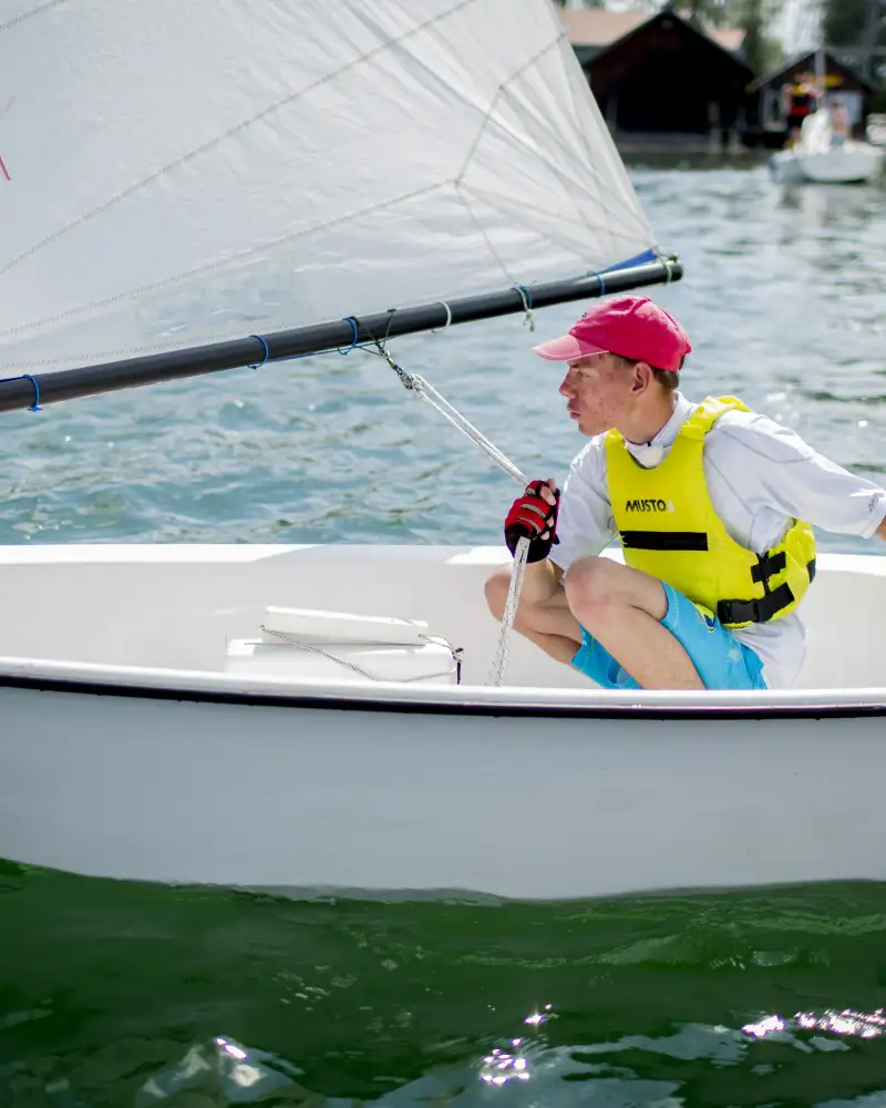 Ein junger Mann in einem kleinen Segelboot.