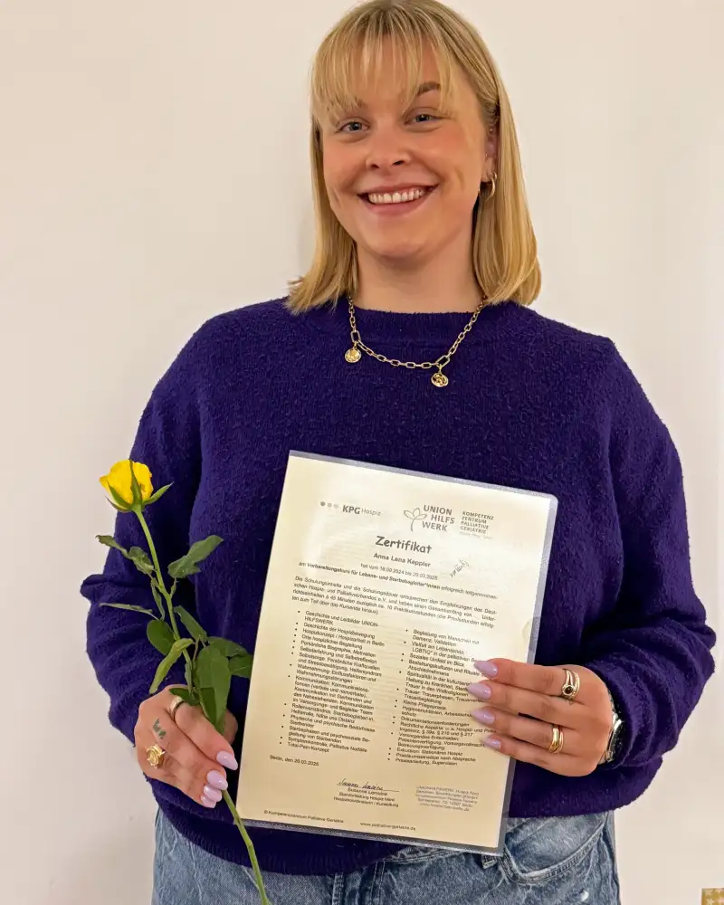Porträt einer blonden jungen Frau, die eine Rose und ein Zertifikat in den Händen hält.