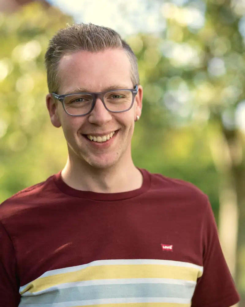 Aktion Mensch-Gewinner Sven steht in seinem Garten.