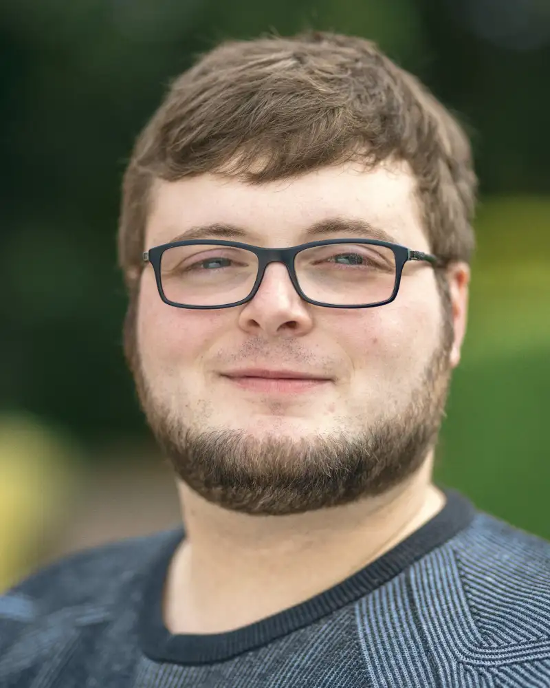 Aktion Mensch-Gewinner Benedict steht im Garten.