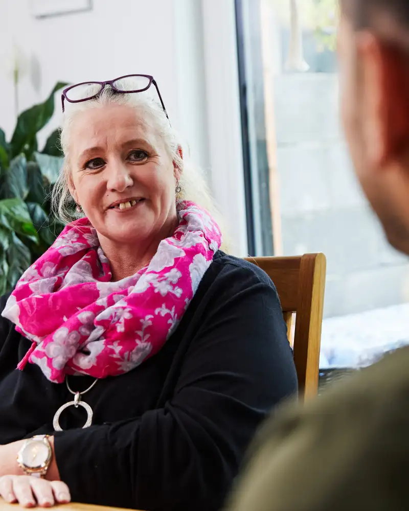 Aktion Mensch-Gewinnerin Tina sitzt an einem Tisch in ihrem Esszimmer.