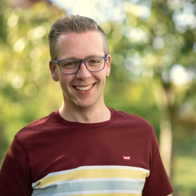 Aktion Mensch-Gewinner Sven steht in seinem Garten.