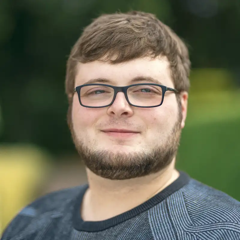 Aktion Mensch-Gewinner Benedict steht im Garten.