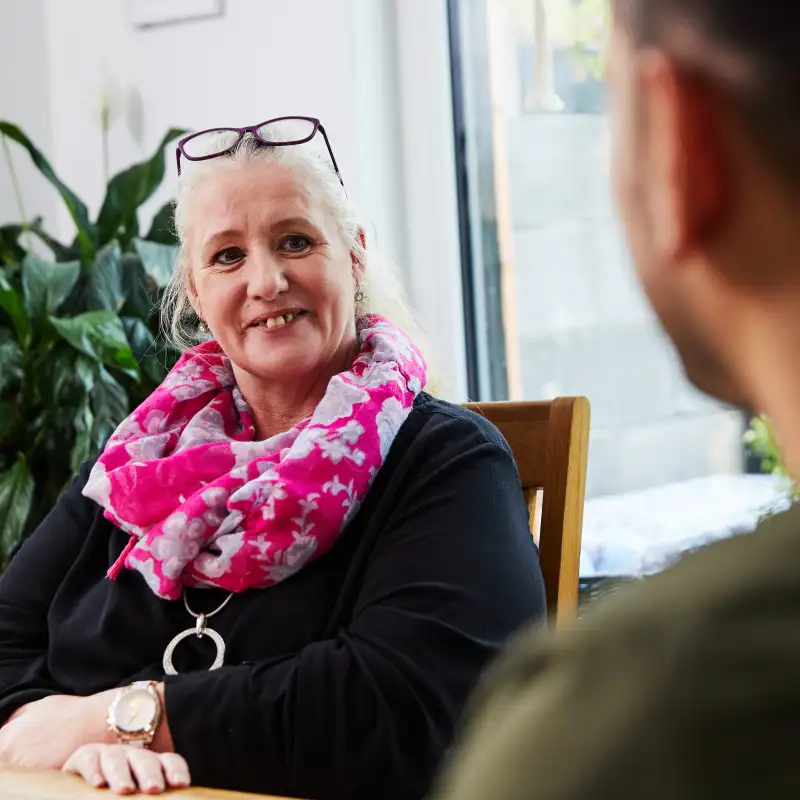 Aktion Mensch-Gewinnerin Tina sitzt an einem Tisch in ihrem Esszimmer.