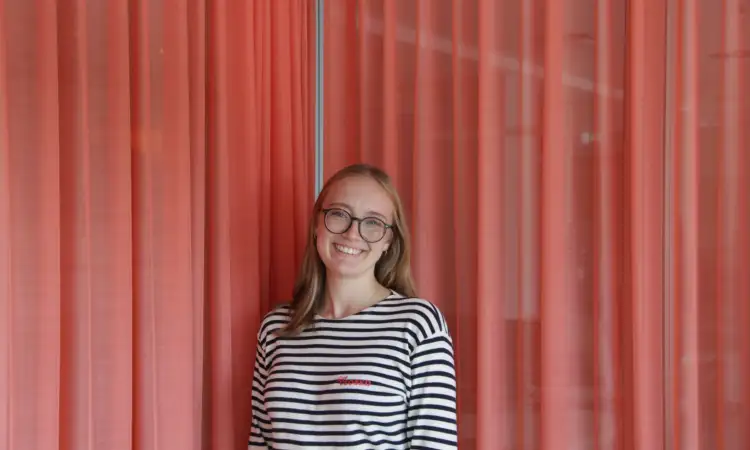 Liska Kurz. Eine junge Frau mit langen blonden Haaren und Brille