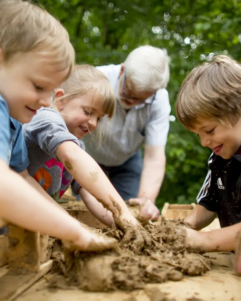 Kinder matschen im Lehm.