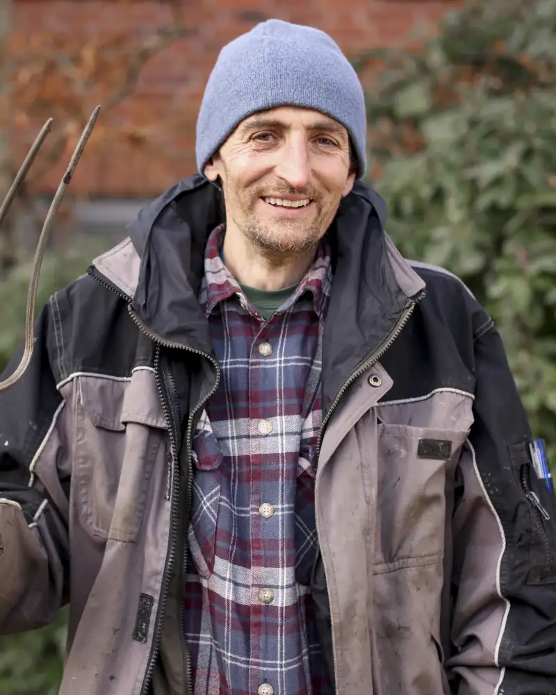 Ein Mann mit Harke im Grünen