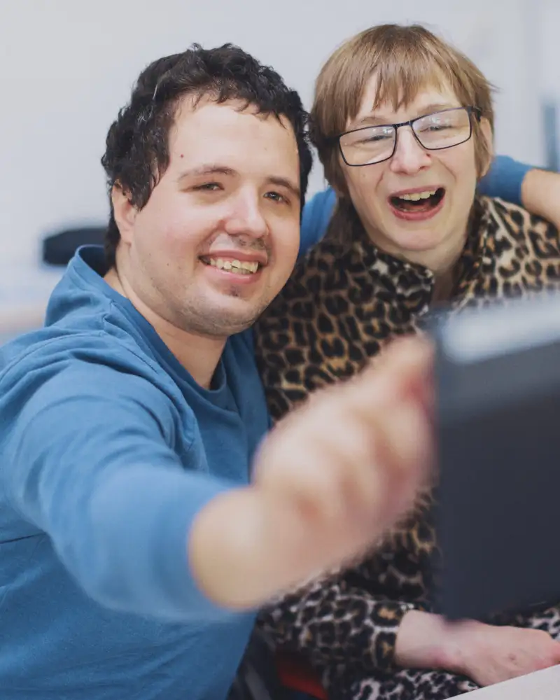 Ein Mann zeigt einer Frau etwas auf einem Tablet.