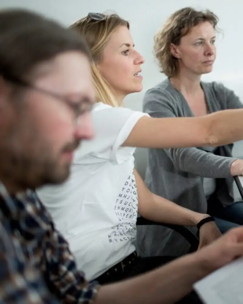 Mehrere Personen mit Laptop an einem Tisch
