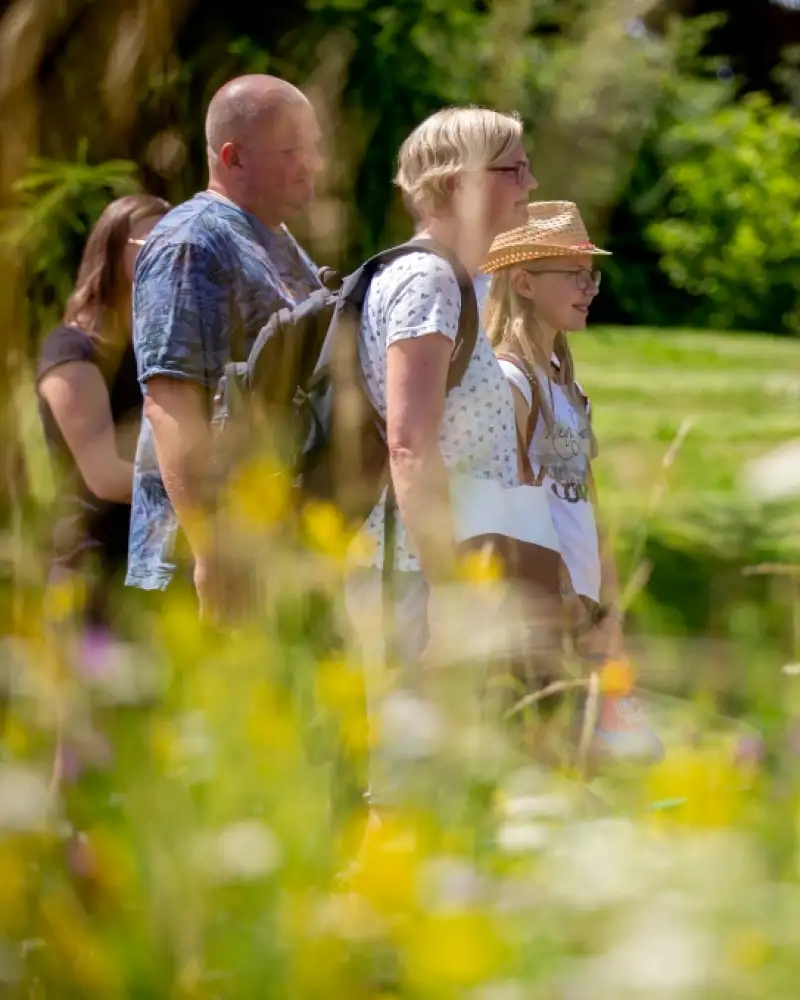 Eine Gruppe von Menschen steht in einem Feld mit Wildblumen