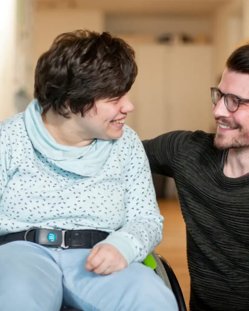 Eine Frau im Rollstuhl und ein Mann sitzen nebeneinander