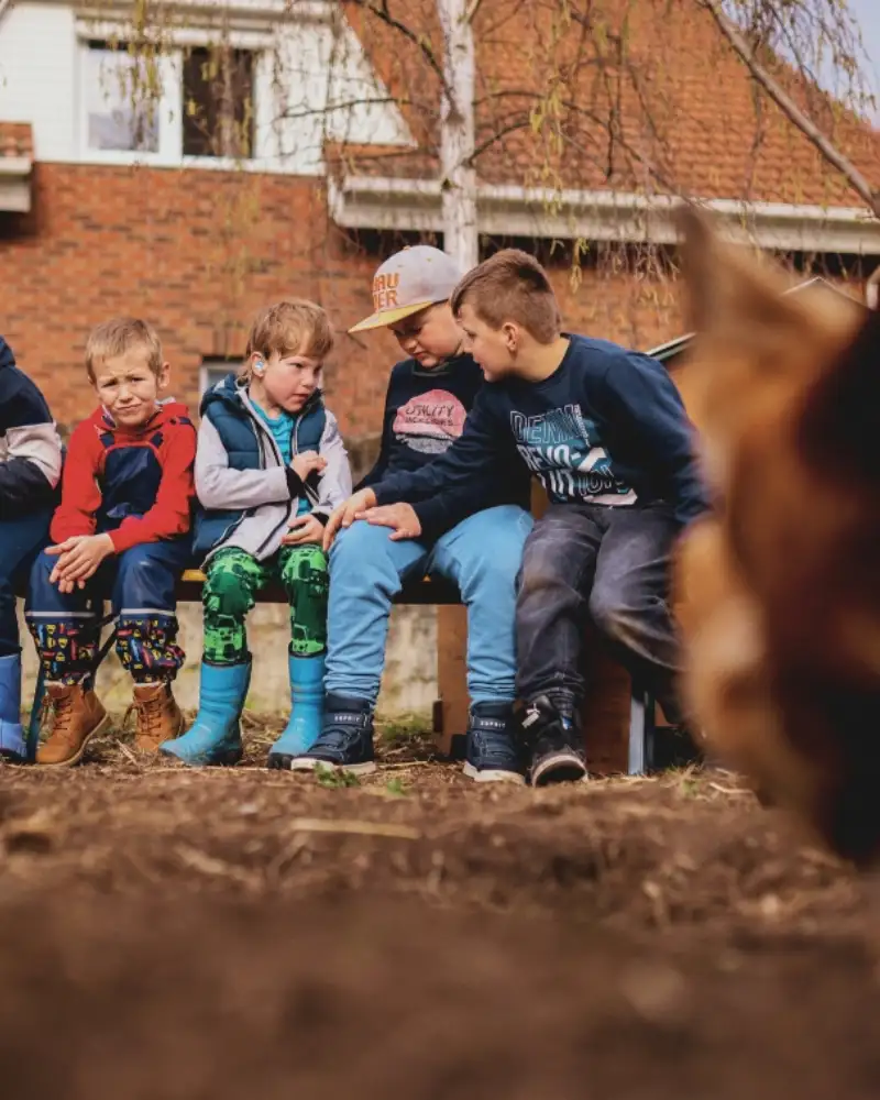 Eine Gruppe von Kindern und ein Huhn auf einem Bauernhof