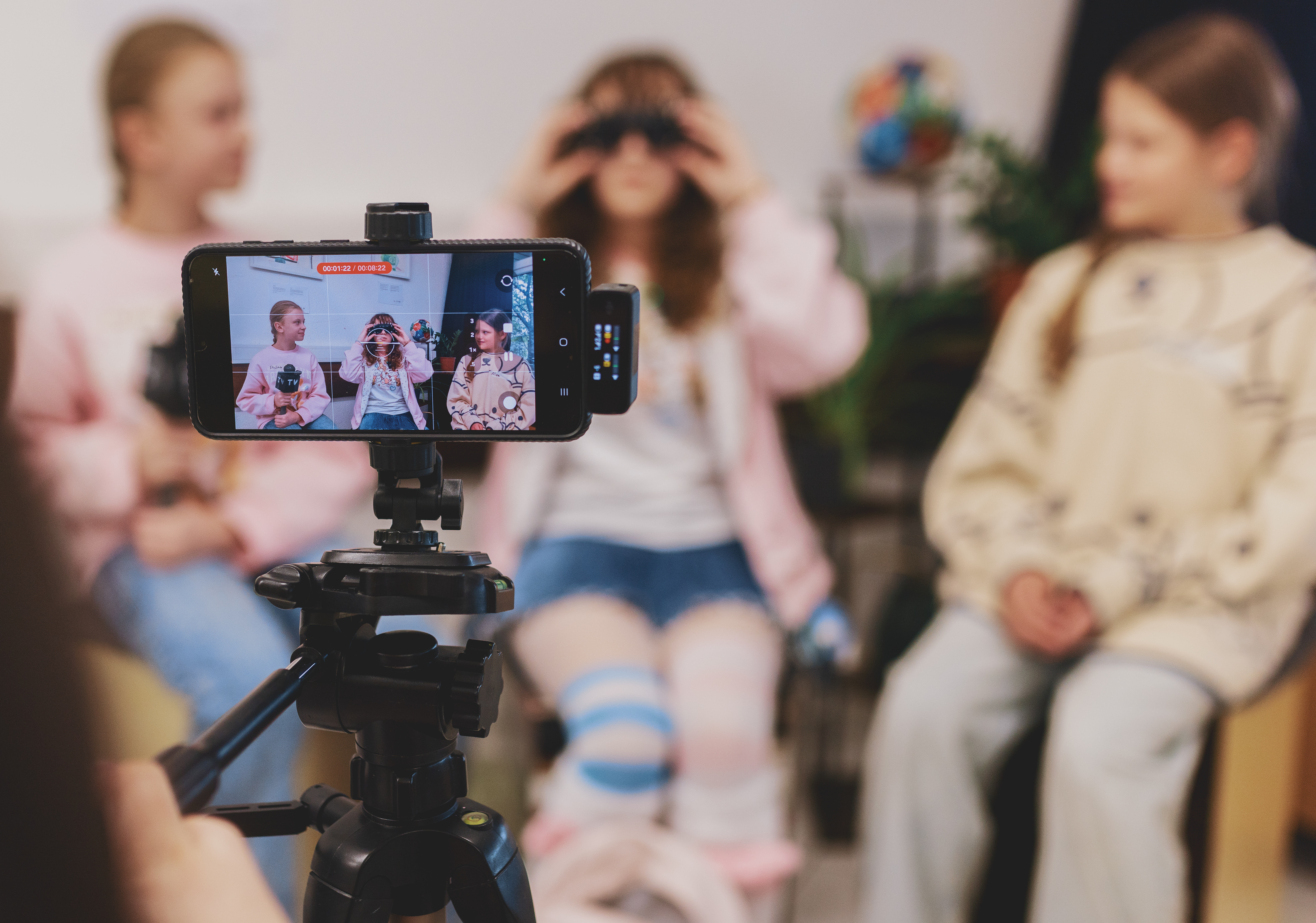 Blick auf ein Handy-Display, während ein Video mit drei Mädchen gedreht wird