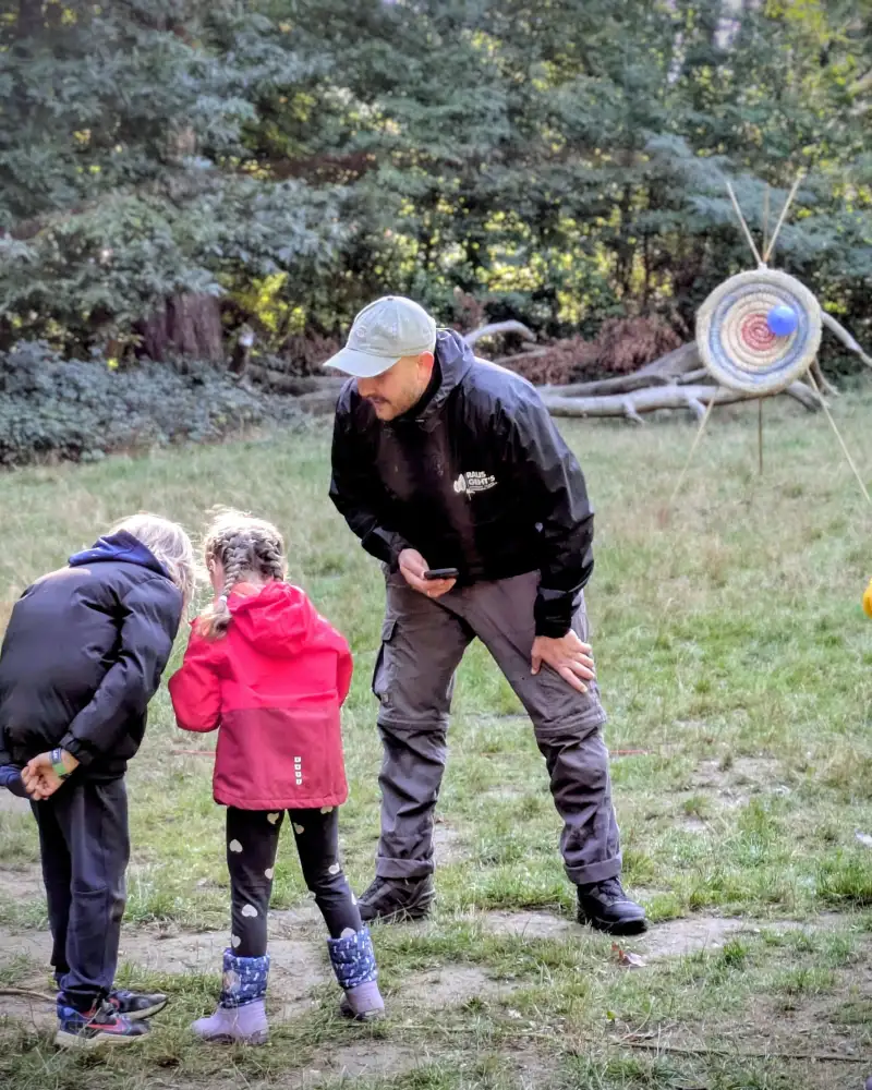 Ein Mann und zwei Kinder auf einer Wiese