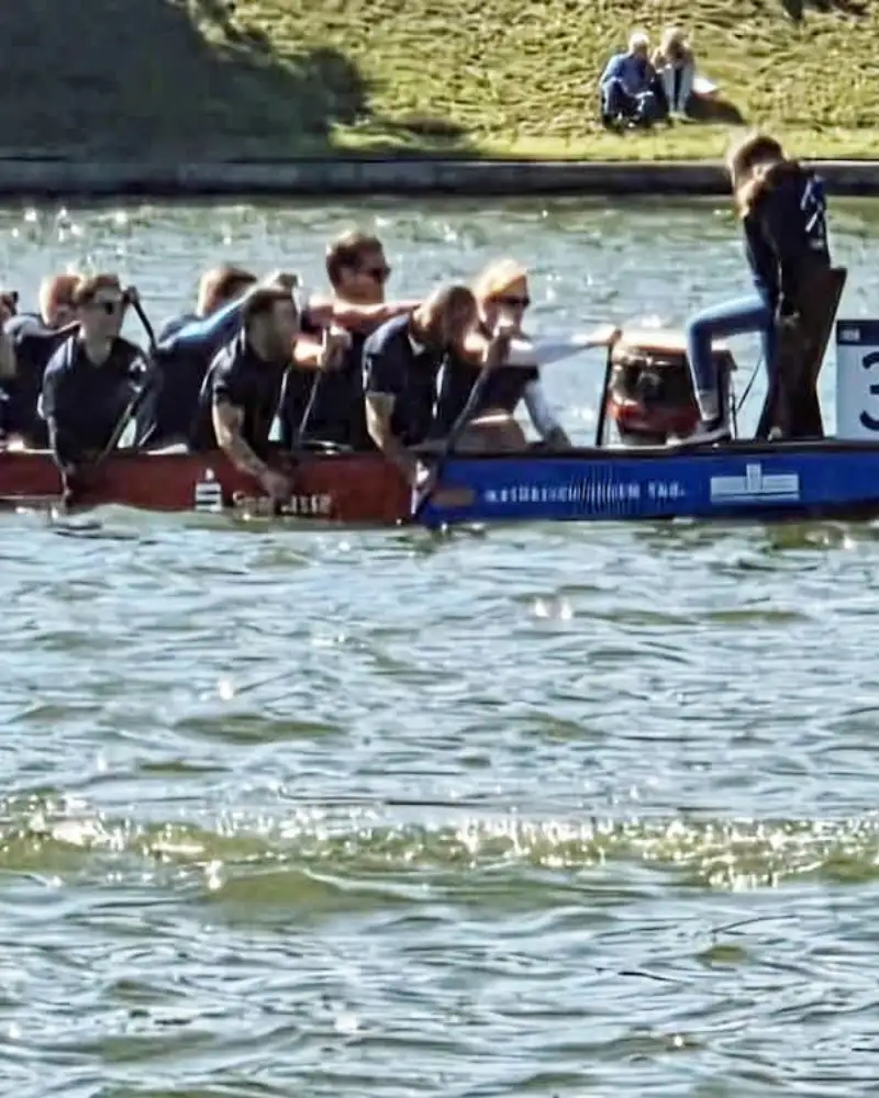 Eine große Gruppe von Menschen in einem Ruderboot auf dem Wasser
