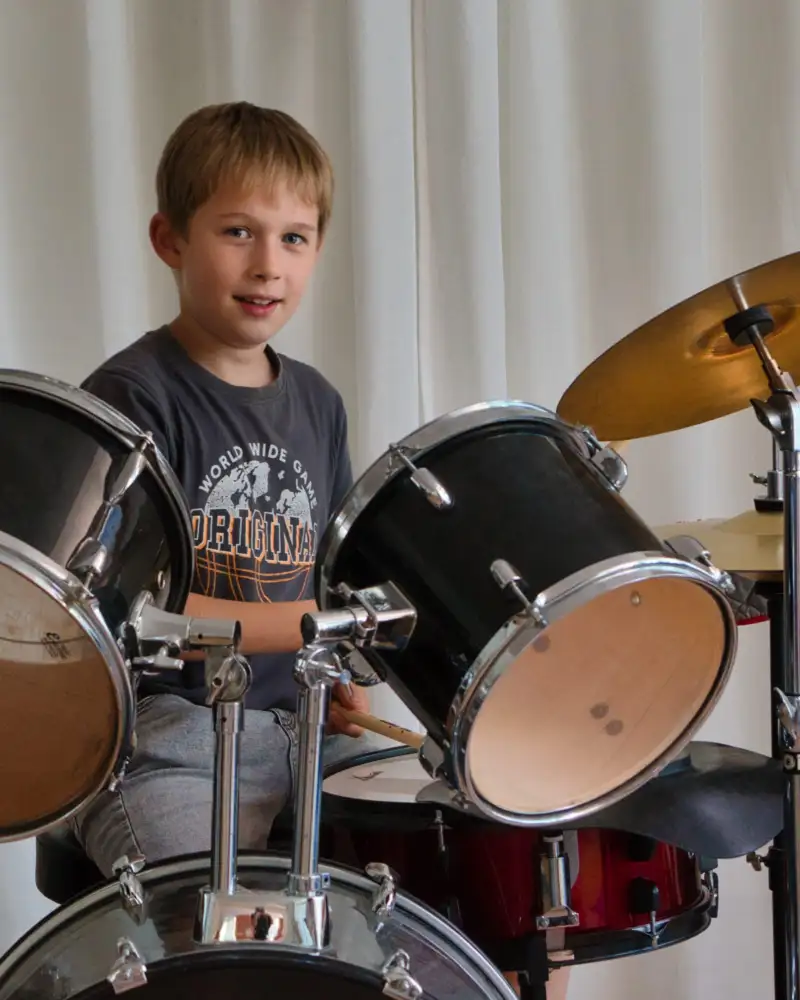 Ein kleiner Junge spielt Schlagzeug.