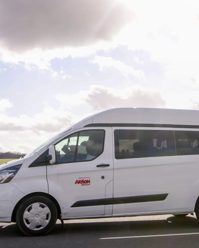Ein weißer Ford Transit fährt durch eine flache Landschaft.