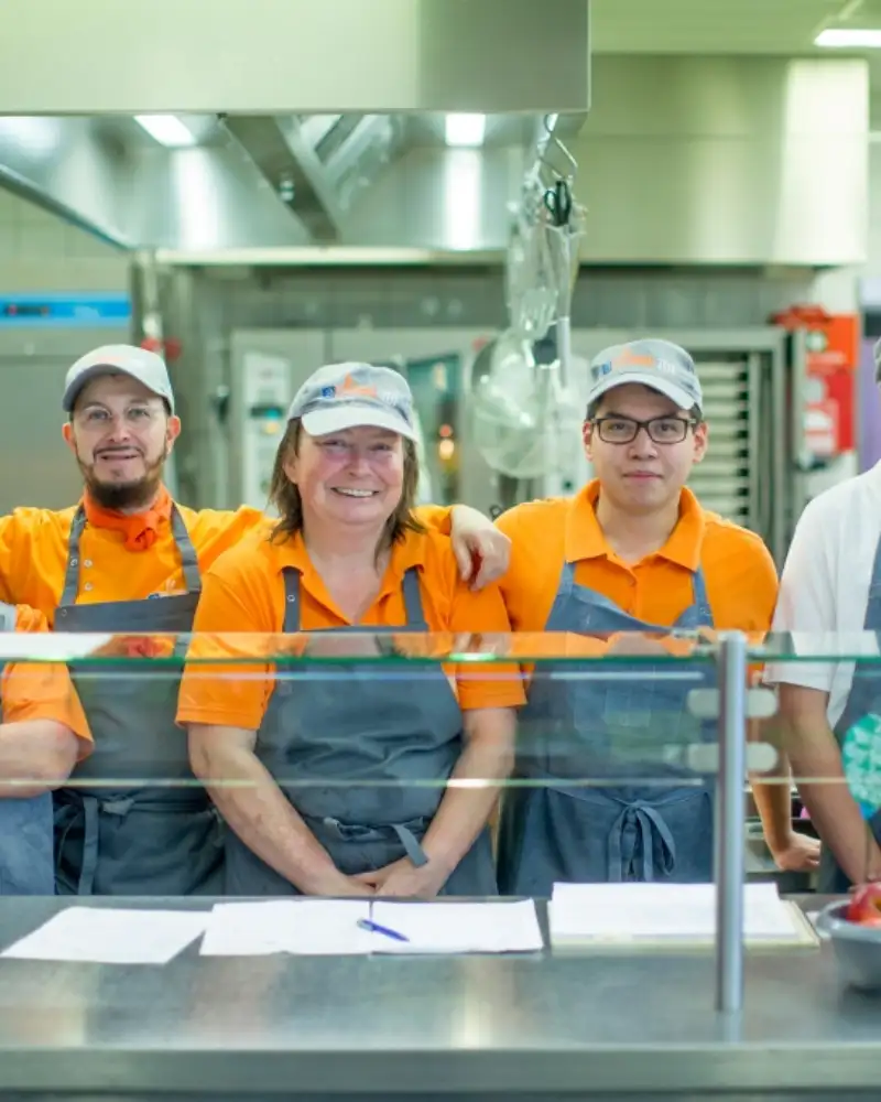 Ein Team von Mitarbeiter*innen hinter der Theke einer Kantine