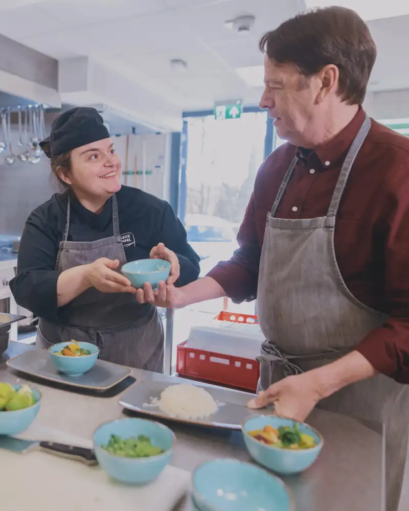 Eine Frau und ein Mann arbeiten in der Küche eines Gastronomiebetriebs