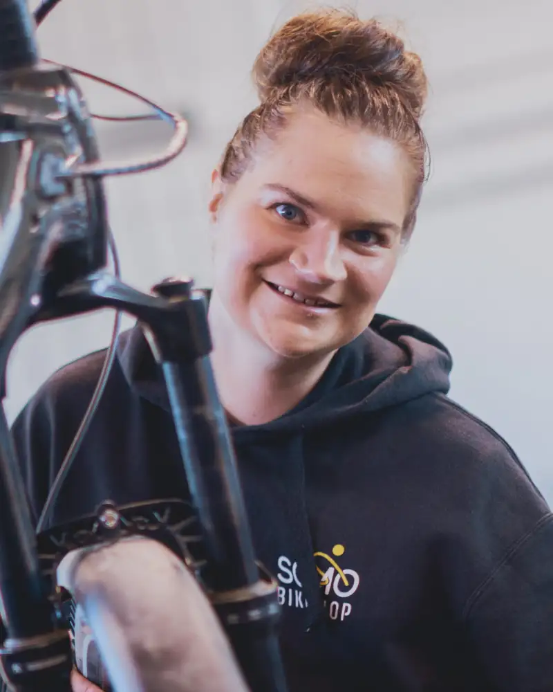 Eine junge Frau bei der Reparatur eines Fahrrads