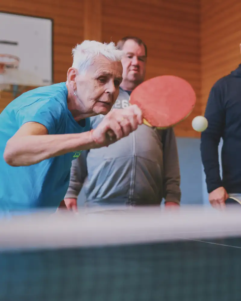 Ältere Dame spielt Tischtennis.