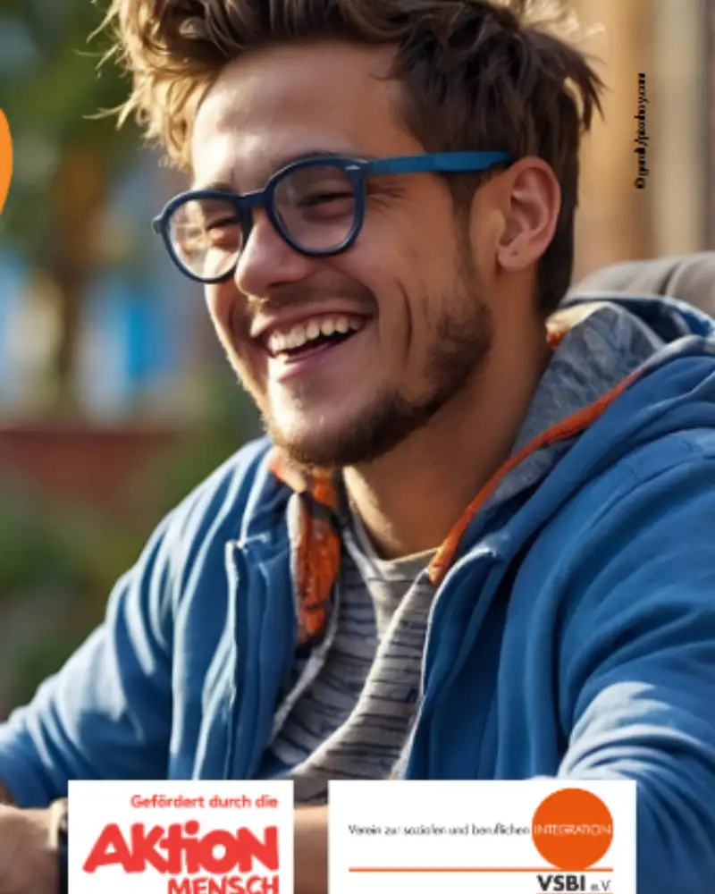 Ein lächelnder junger Mann an einem Laptop