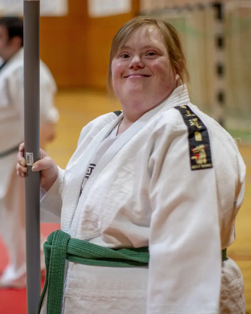 Eine junge Frau mit Downsyndrom in Kampfsportkleidung