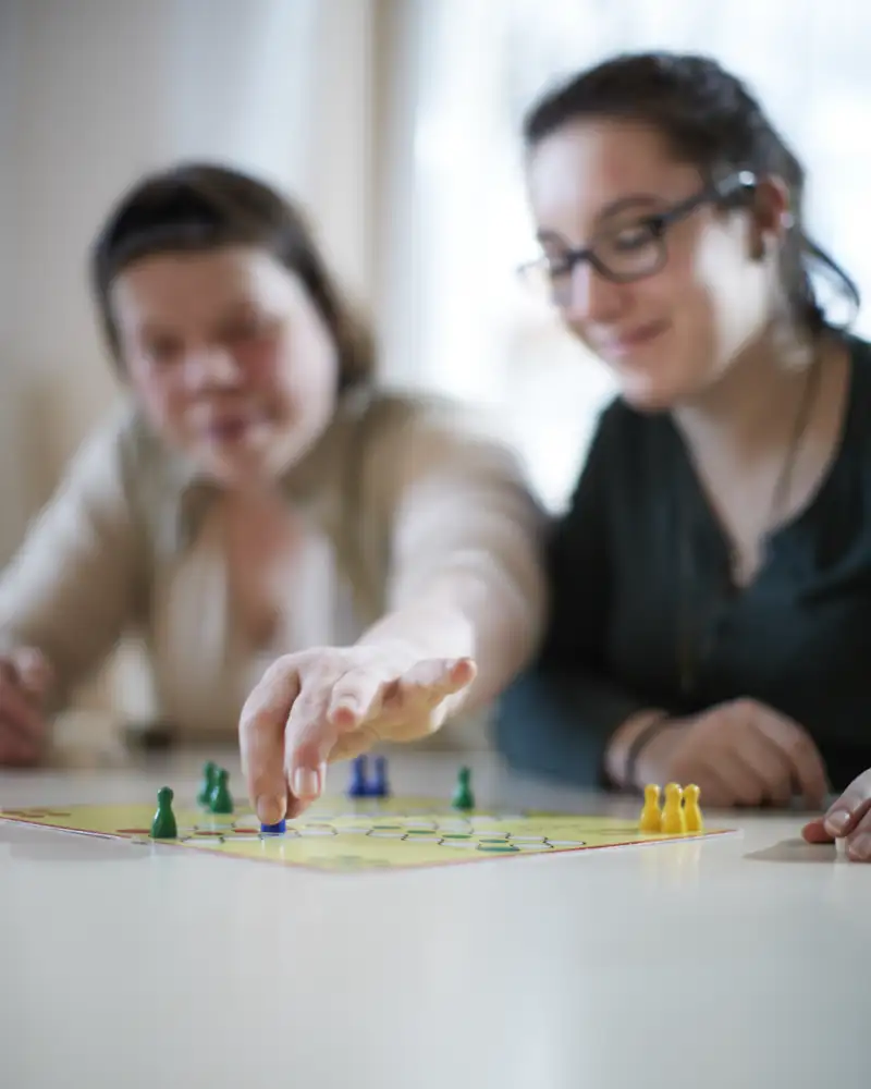 Zwei Frauen spielen das Brettspiel "Mensch Ärgere dich nicht".