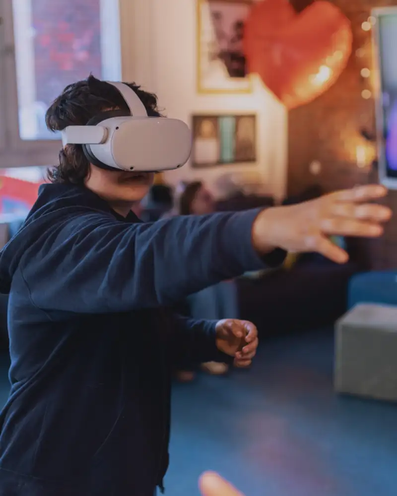 Eine Jugendliche trägt eine VR-Brille und streckt ihren Arm aus.