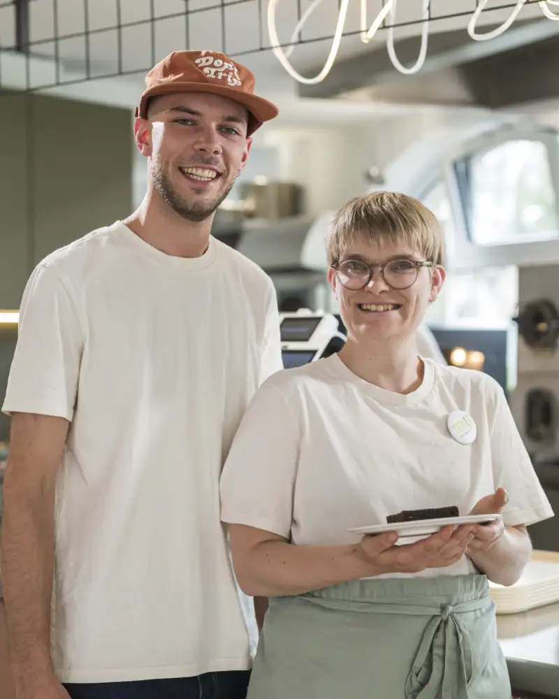 Eine Frau mit einem Teller in der Hand und ein Mann stehen in einer Küche