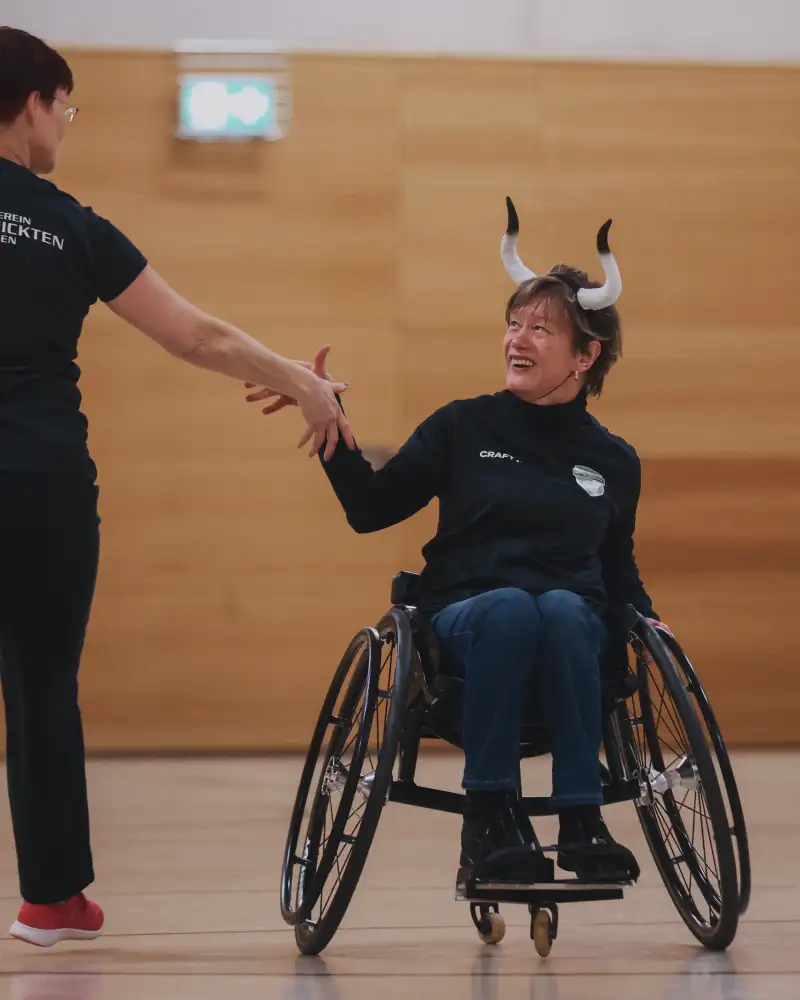 Eine Frau im Rollstuhl tanzt mit einer gehenden Frau. Sie sind als Stier und Matador verkleidet.