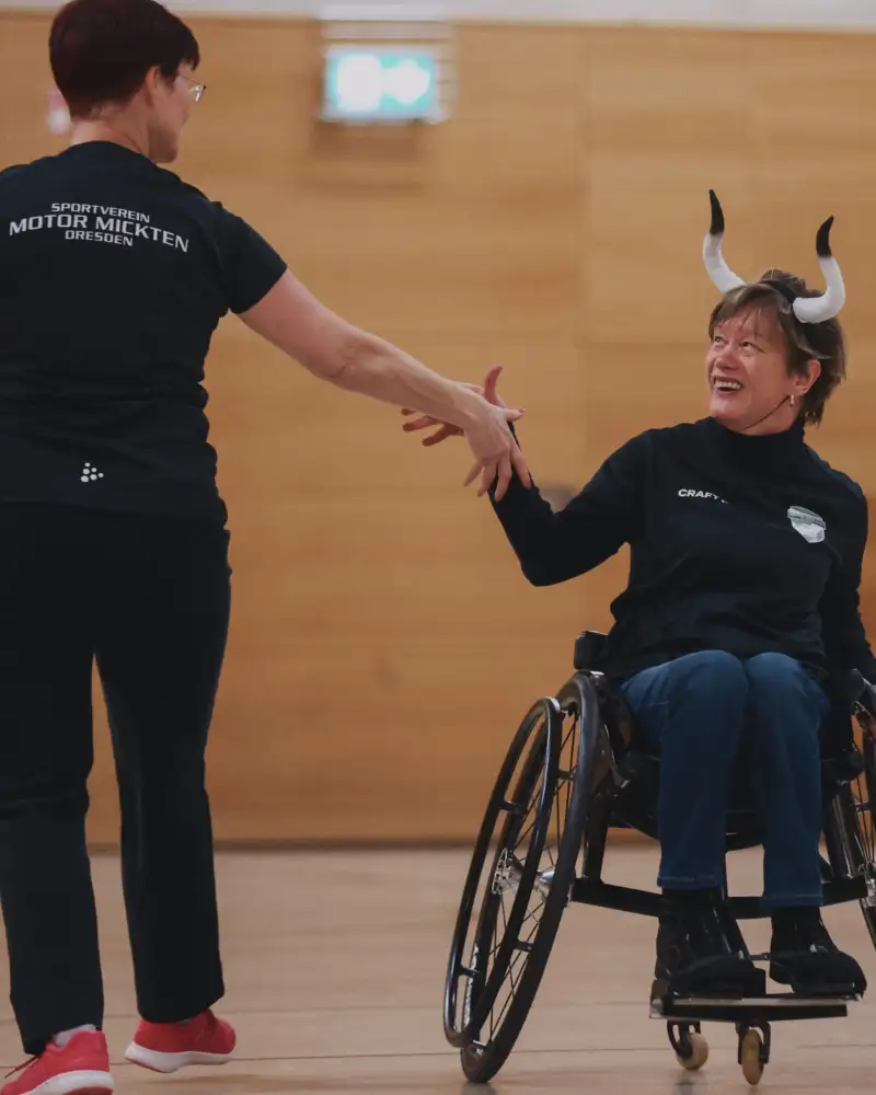 Eine Frau im Rollstuhl tanzt mit einer gehenden Frau. Sie sind als Stier und Matador verkleidet.