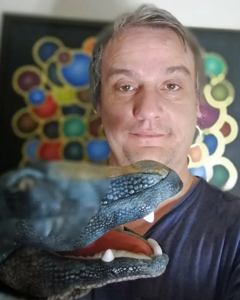 Porträtfoto eines Mannes mit einer Krokodil-Handpuppe