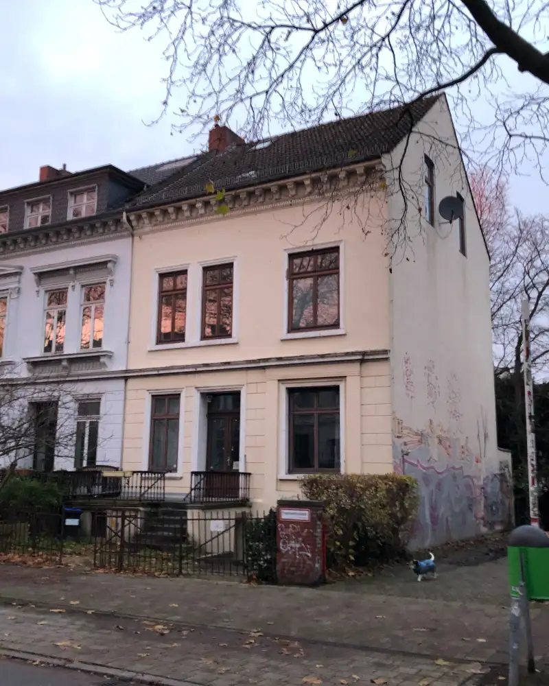 Drei aneinandergebaute zwei Altbauten mit je zwei Etagen und ausgebauten Dächern sowie Vorgärten.