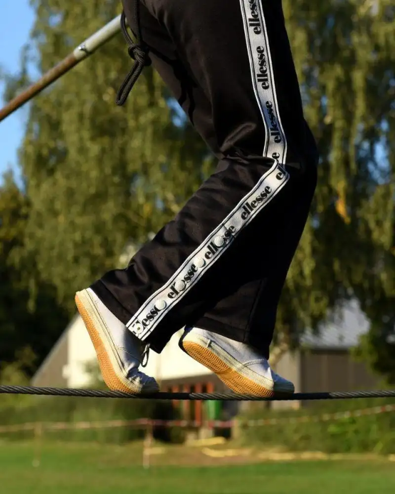 Füße einer Person, die auf einem Hochseil balanciert