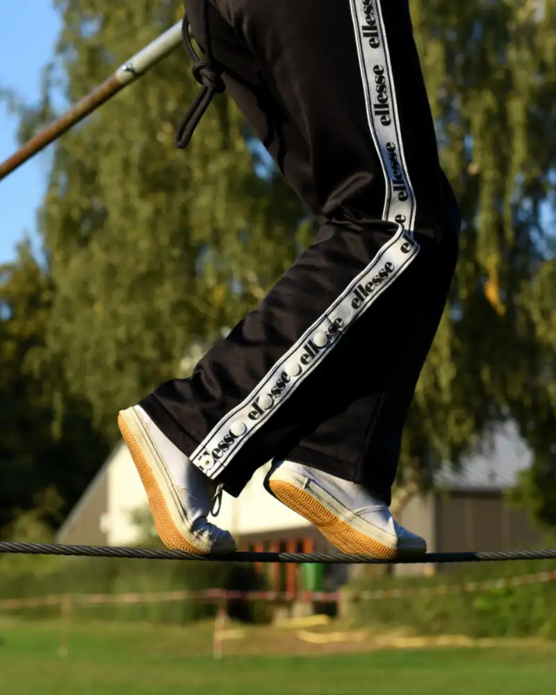 Füße einer Person, die auf einem Hochseil balanciert
