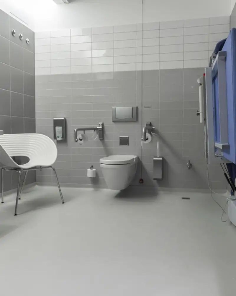Innenaufnahme einer barrierefreien Toilettenanlage mit Pflegeliege