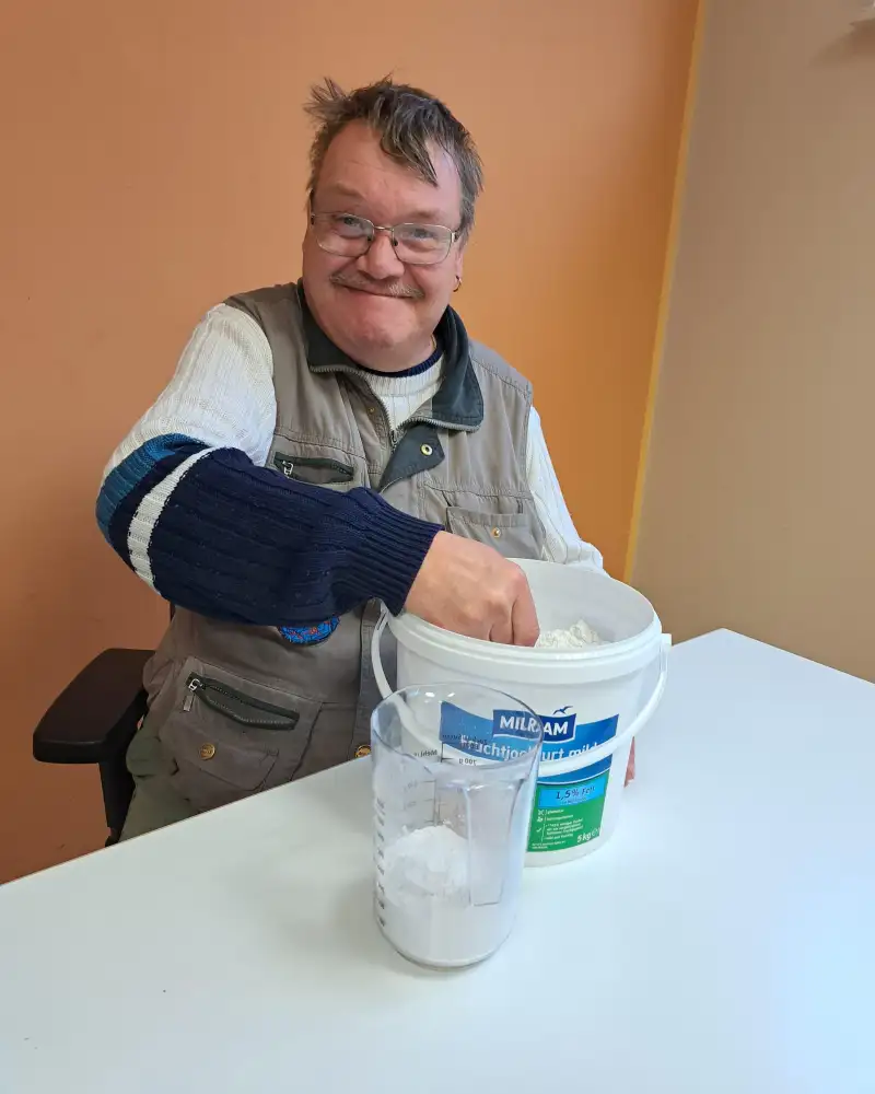 Ein Mann mit geistiger Behinderung arbeitet an einem Tisch mit Gips.