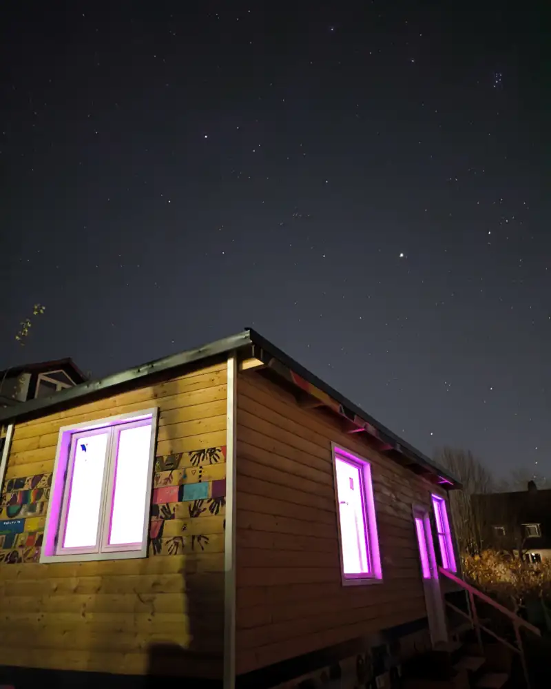 Eine Holzhütte mit erleuchteten Fenstern bei Nacht