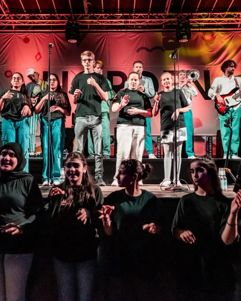 Auftrittsfoto von einerBand und einem Gebärdensprach-Chor