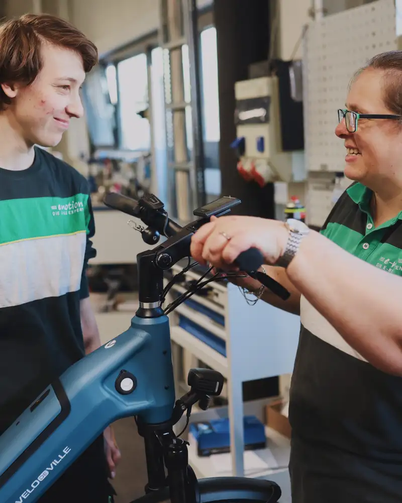 Zwei Frauen reparieren den Lenker eines Fahrrads.