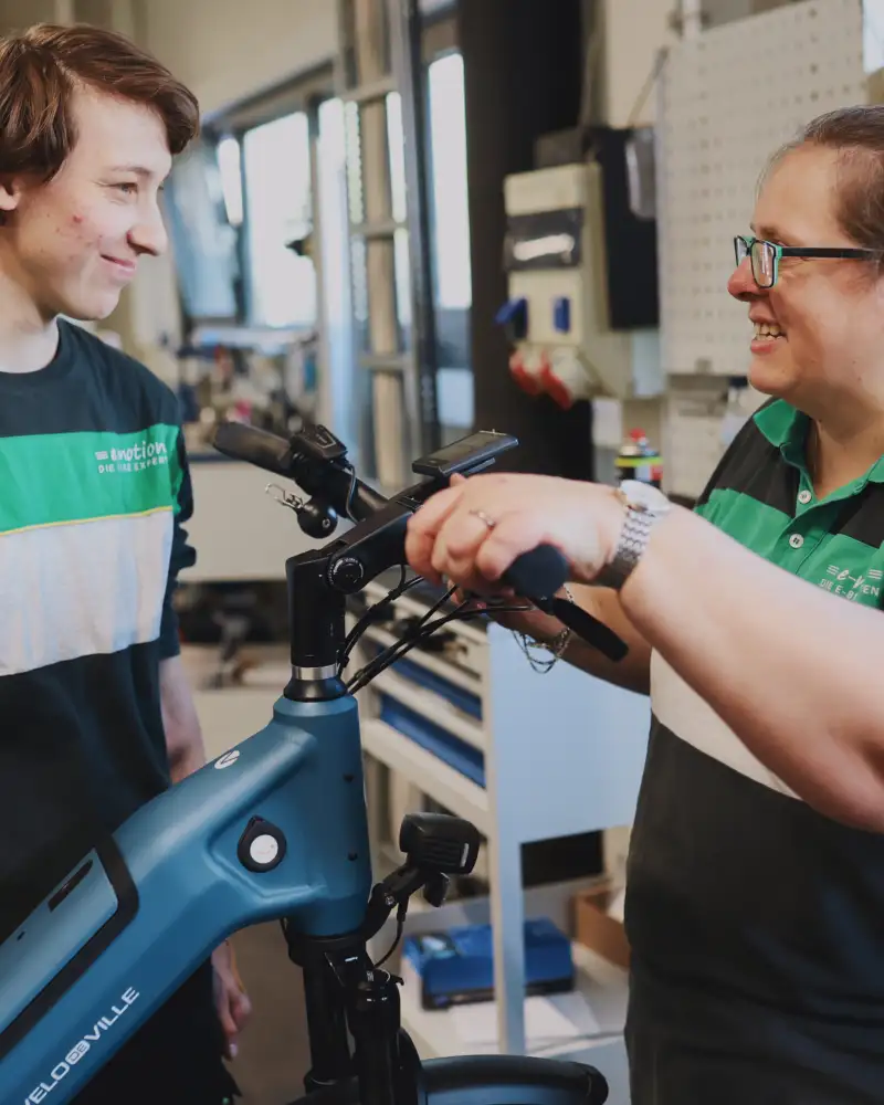 Zwei Frauen reparieren den Lenker eines Fahrrads.