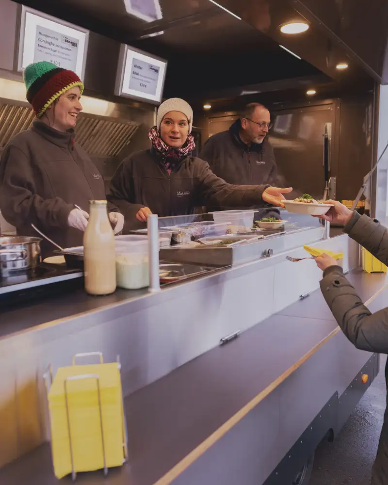 Mehrere Menschen vor einem Streetfood-Anhänger